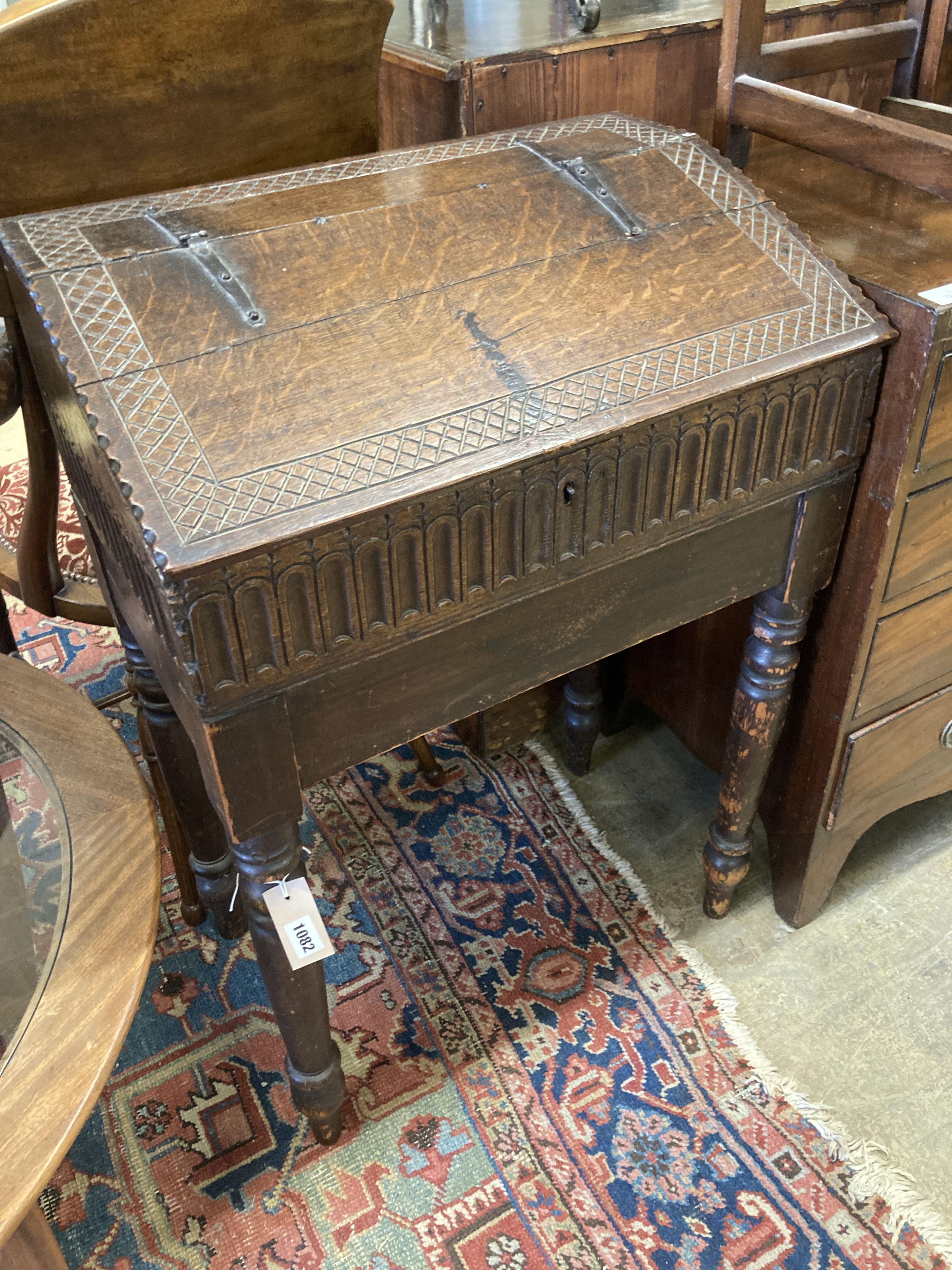 A 17th century oak slant front bible box, raised on a stand